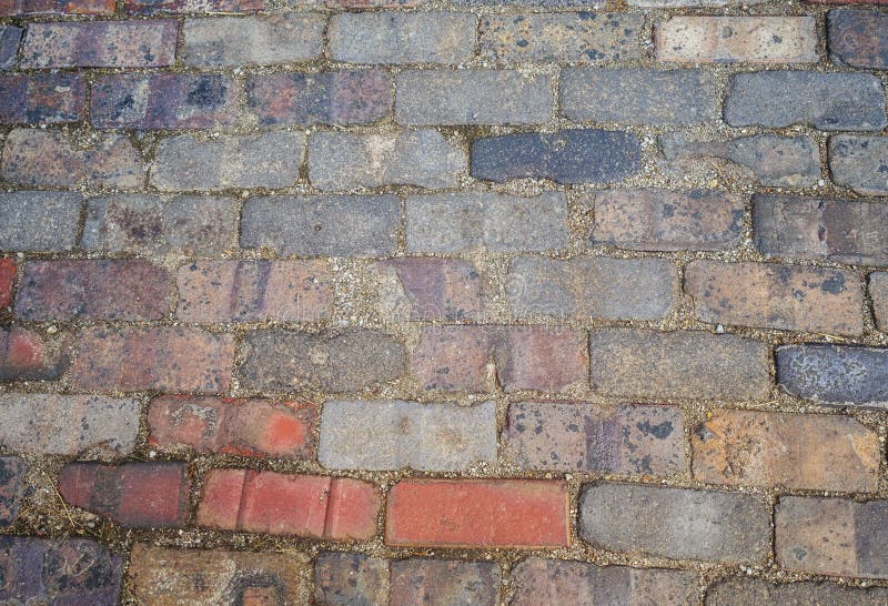 Multicolored brick cobblestones abstract background texture with shades of gray red orange blue and pink. Taken in Victorian Village, Columbus, Ohio USA For use as computer wallpaper and for concept of security solidity strength. Multicolored brick cobblestones abstract background texture with shades of gray red orange blue and pink. Taken in Victorian Village, Columbus, Ohio USA For use as computer wallpaper and for concept of security solidity strength