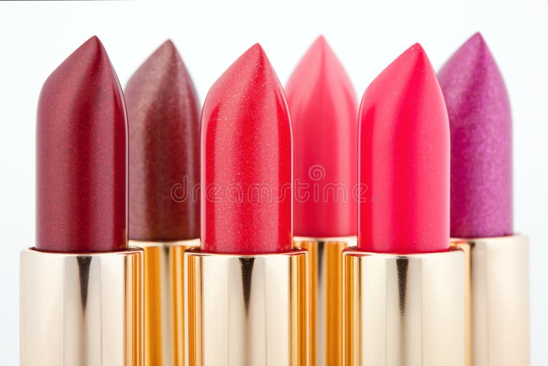 Multicolored color lipsticks arranged in two lines isolated on white, shallow depth of field