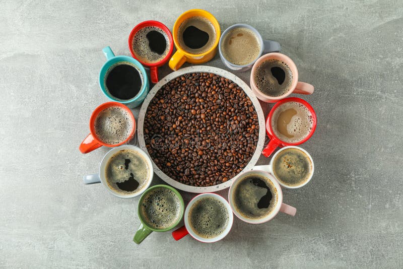 Multicolored cups of coffee and coffee beans on grey background, top view stock photography Multicolored cups of coffee and coffee beans on grey background, top view stock photography