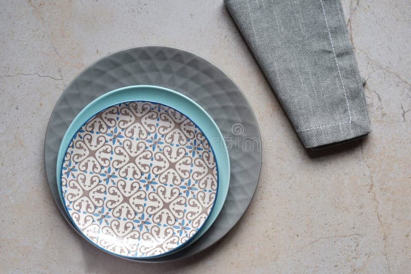 Multicolored empty ceramic plates and bowls on a marble background. Table setting. Shabby chic or retro style. Copy space. Mock up stock photo Multicolored empty ceramic plates and bowls on a marble background. Table setting. Shabby chic or retro style. Copy space. Mock up stock photo