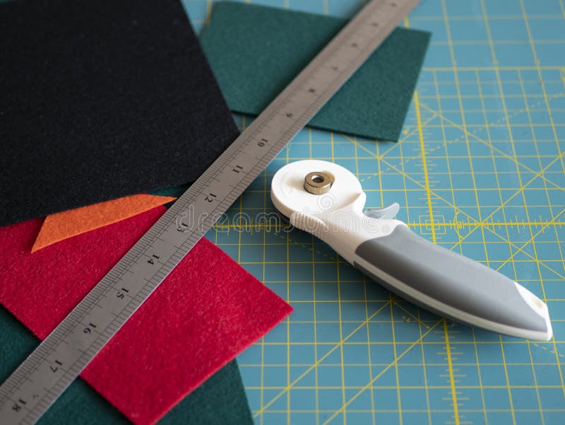 Multicolored Felts a Rotary Cutter and a Ruler on the Cutting Mat