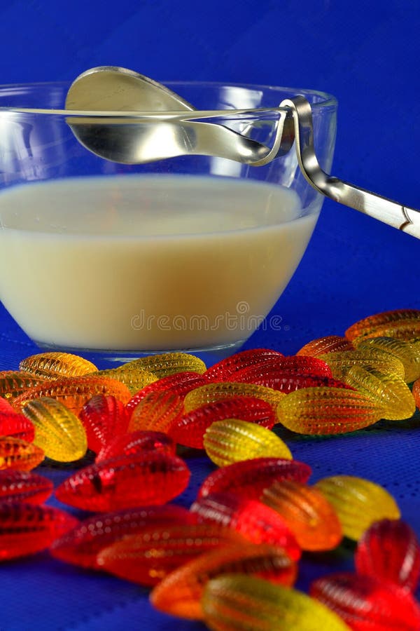 Multicolored marmelade en een kop van melk met lepel royalty-vrije stock fotografie Multicolored marmelade en een kop van melk met lepel royalty-vrije stock fotografie