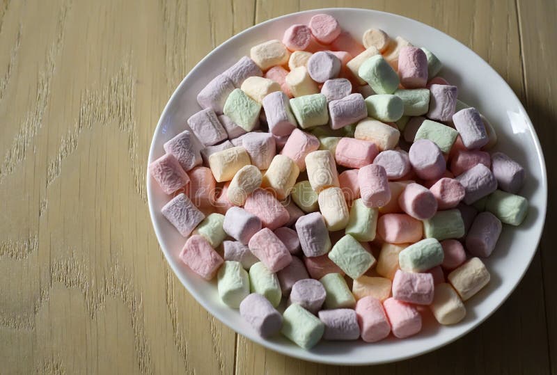 Multicolored marshmallows on a white plate stock photos
