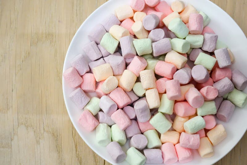 Multicolored marshmallows on a white plate royalty free stock photo