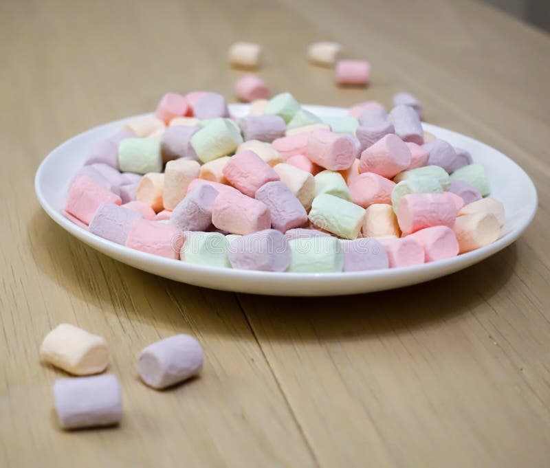 Multicolored marshmallows on a white plate royalty free stock image