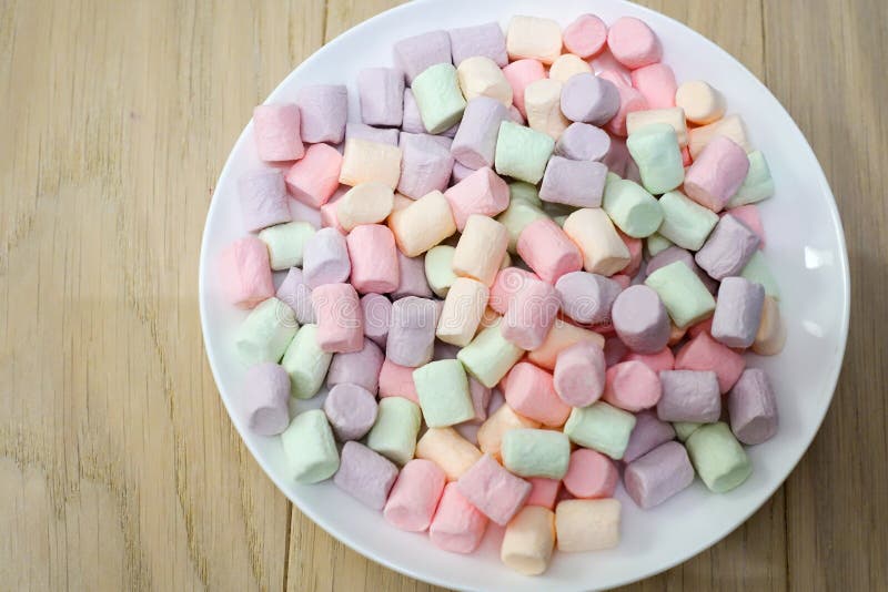 Multicolored marshmallows on a white plate royalty free stock photos