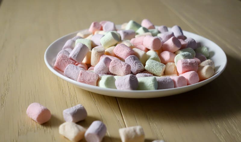 Multicolored marshmallows on a white plate stock image