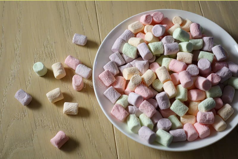 Multicolored marshmallows on a white plate stock images