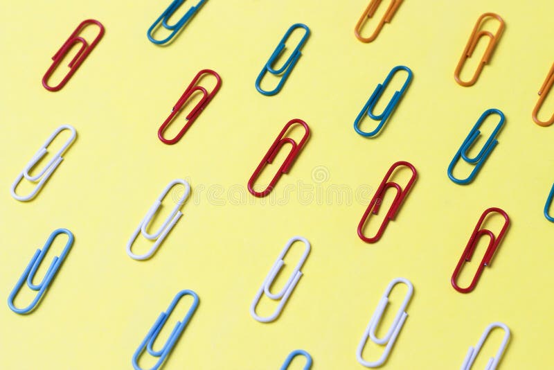 Multicolored Paper Clips on a Yellow Background, Office Concept Stock