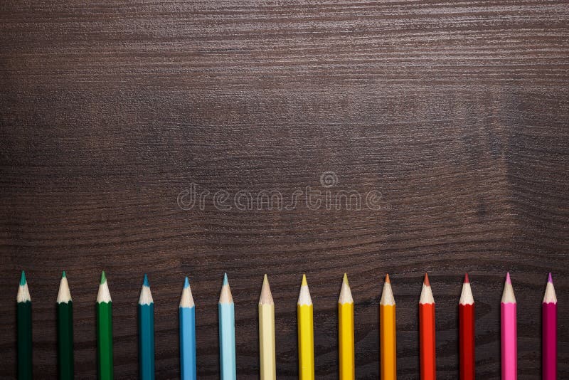 Multicolored pencils over brown wooden table stock photos Multicolored pencils over brown wooden table stock photos