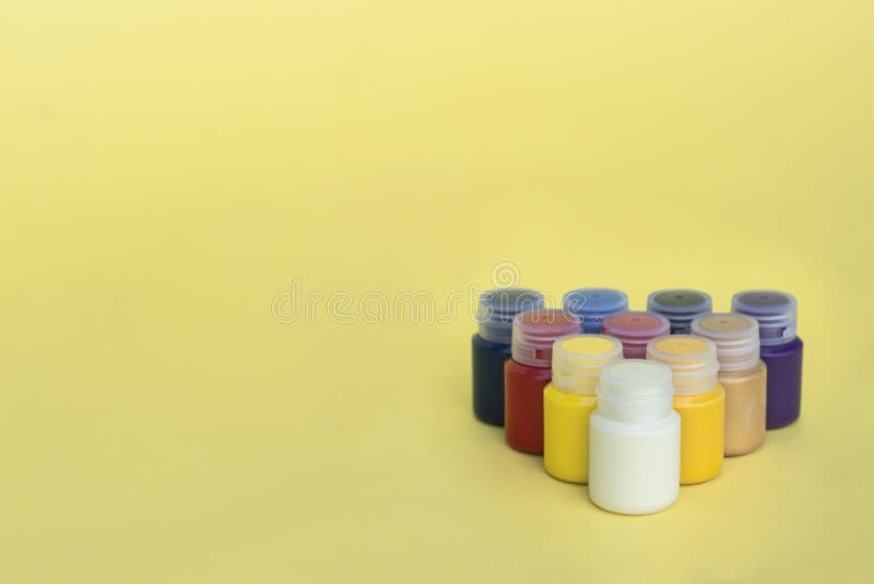 Multicolored plastic cans with acrylic paint on a yellow background. Art supplies. Set for the artist. royalty free stock photo Multicolored plastic cans with acrylic paint on a yellow background. Art supplies. Set for the artist. royalty free stock photo