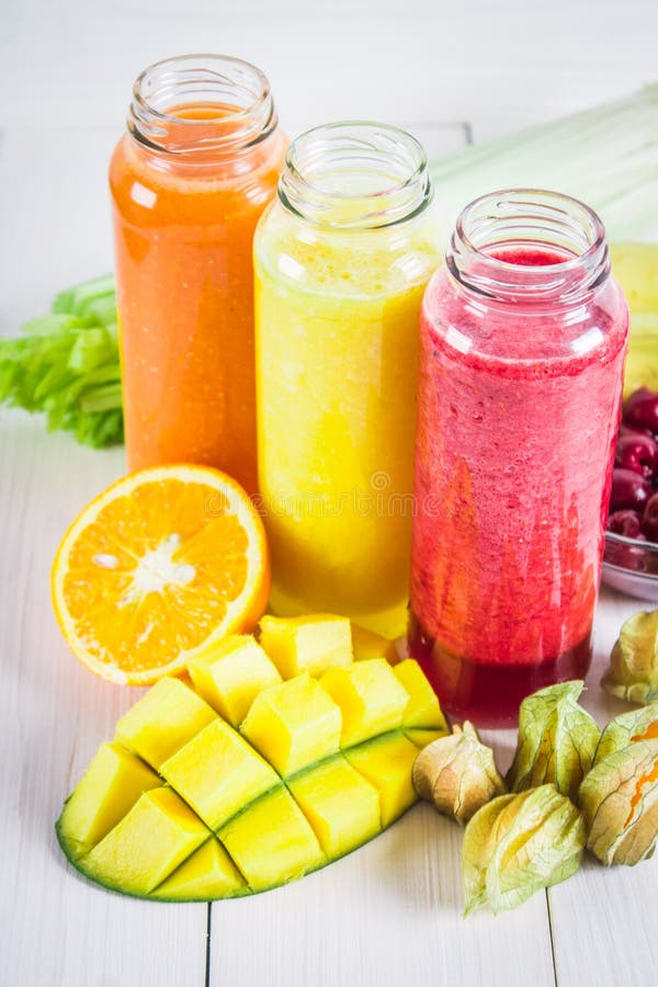 Multicolored Smoothies in Bottles of Mango, Orange, Banana, Celery
