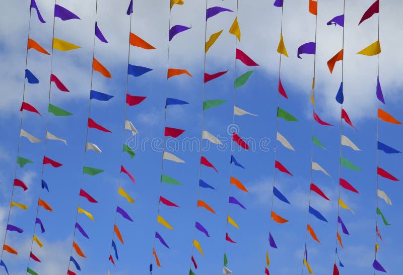 Multicolored Triangular Small Flags To Celebration Party Against Blue