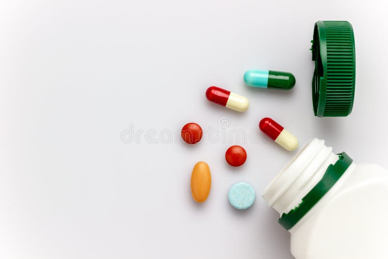Multicoloured capsules with white medicine bottles and green caps. stock image Multicoloured capsules with white medicine bottles and green caps. stock image
