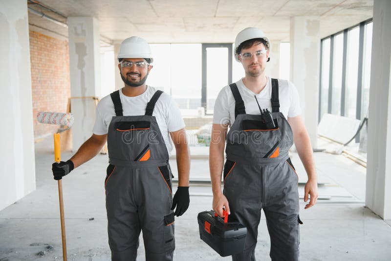 Multicultural builders in hardhats at construction site stock photos