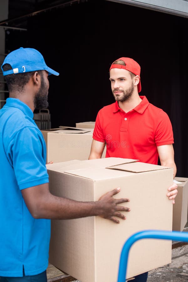 Multicultural Delivery Men in Red and Blue Uniform with Cardboard Stock