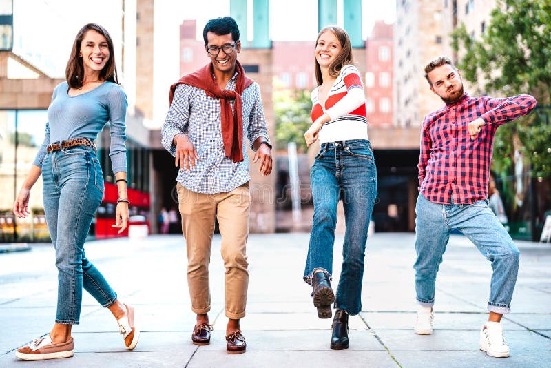 Multicultural friends walking at city center acting funny crazy moves - Happy guys and girls having fun by urban streets stock image