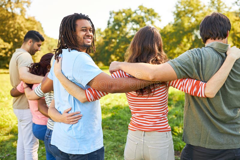 Multicultural Group of Young People Standing Arm in Arm Stock Image