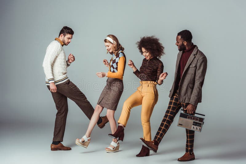 multicultural retro styled friends dancing with vintage radio