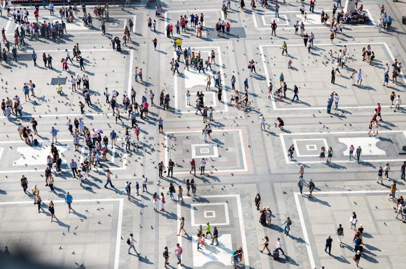 Milan, Italy, September 9, 2018: Crowd of small figures of many people are walking and a lot of pigeons on Piazza del Duomo square in city centre, top view from the roof of Duomo di Milano cathedral. Milan, Italy, September 9, 2018: Crowd of small figures of many people are walking and a lot of pigeons on Piazza del Duomo square in city centre, top view from the roof of Duomo di Milano cathedral