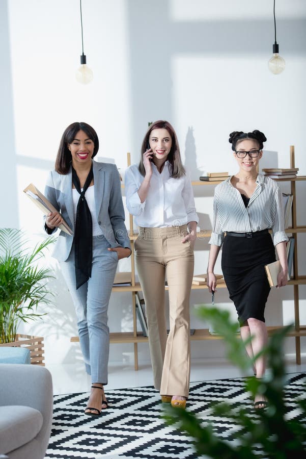 Multiethnic Businesswomen Walking at Office Together and Looking at ...