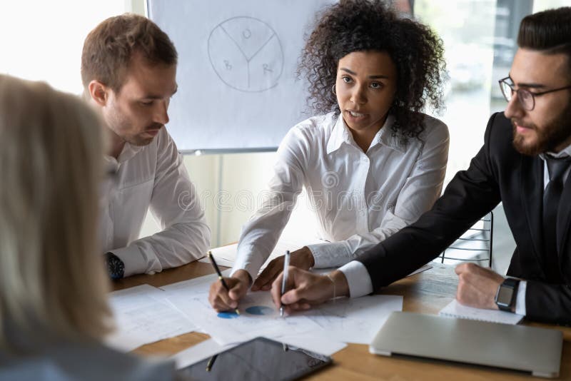 Multiethnic colleagues discussing financial paperwork at briefing royalty free stock images Multiethnic colleagues discussing financial paperwork at briefing royalty free stock images