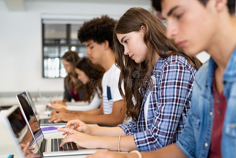 Group Of High School Students Using Laptop In Classroom Stock Image
