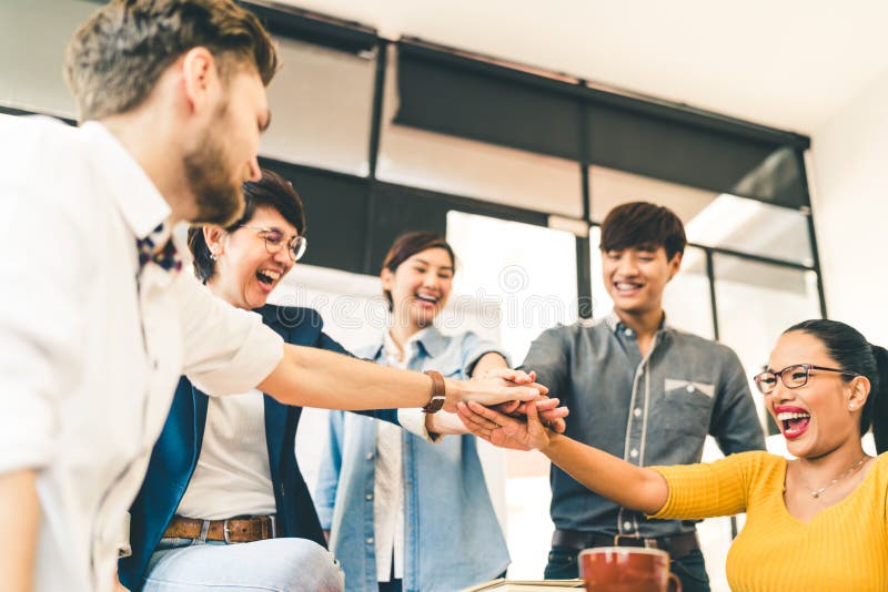 Multiethnic diverse group of happy colleagues join hands together. Creative team, casual business coworker, or college students