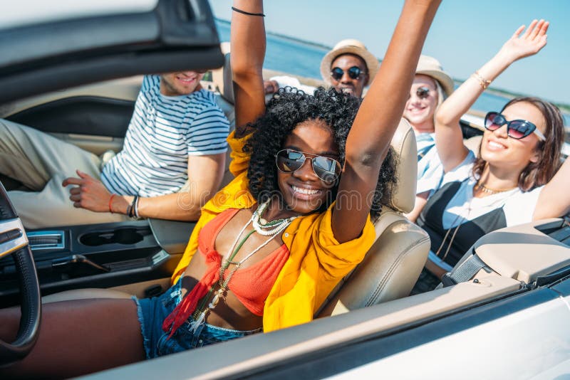 multiethnic smiling friends riding car while. Summertime, multicultural.