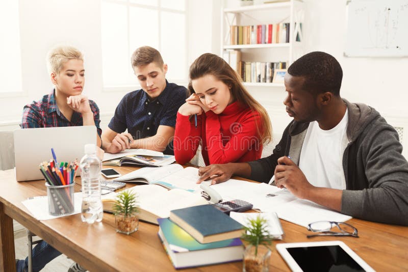 Multiethnische Mitschüler, die sich zusammen für Prüfungen vorbereiten lizenzfreie stockfotos Multiethnische Mitschüler, die sich zusammen für Prüfungen vorbereiten lizenzfreie stockfotos