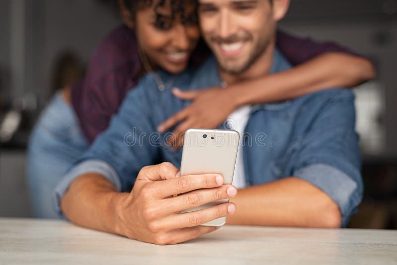 Multietniska par genom att använda telefonen arkivbilder Multietniska par genom att använda telefonen arkivbilder