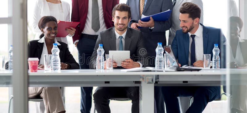 Multietniskt team av anställda vid bordet arkivfoto