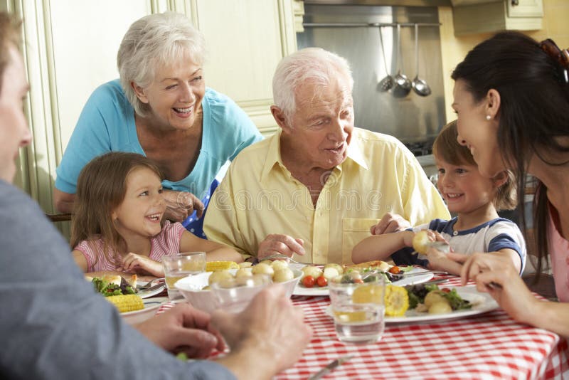 Multigeneratiefamilie die Maaltijd samen in Keuken eten royalty-vrije stock fotografie Multigeneratiefamilie die Maaltijd samen in Keuken eten royalty-vrije stock fotografie