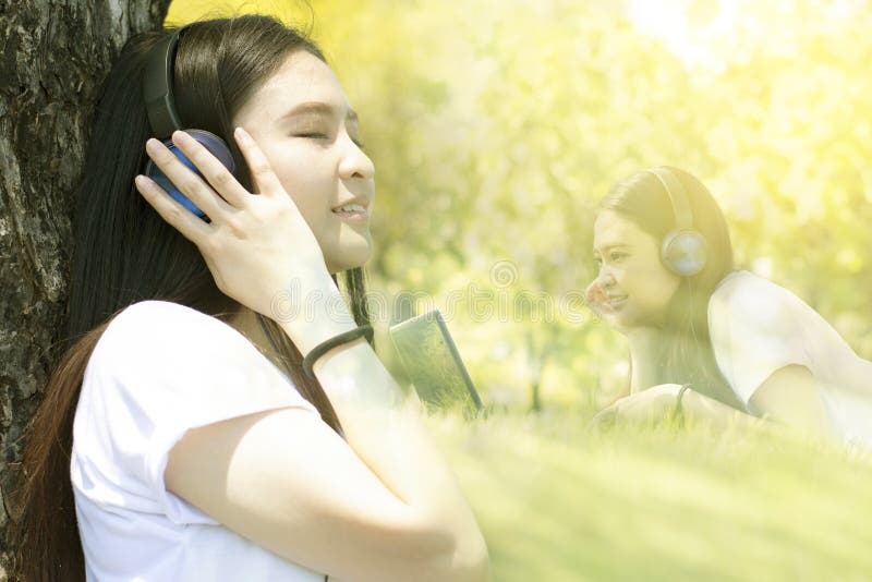 Multiple exposure of young Asian woman is enjoy listening to music in the Park. Multiple exposure of young Asian woman is enjoy listening to music in the Park.