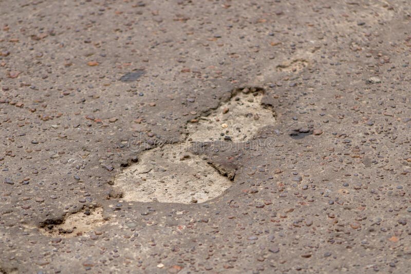 Multiple pot holes in paved road royalty free stock photo