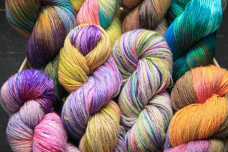 Multiple skeins of colourful handdied sock yarn, sock wool, with extreme vibrant colours for knitting socks and other craft projects as a hobby.