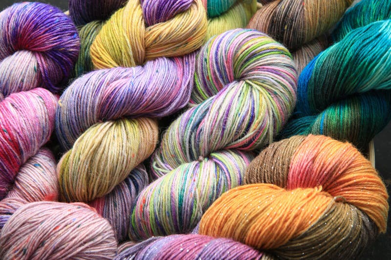 Multiple skeins of colourful handdied sock yarn, sock wool, with extreme vibrant colours for knitting socks and other craft projects as a hobby.