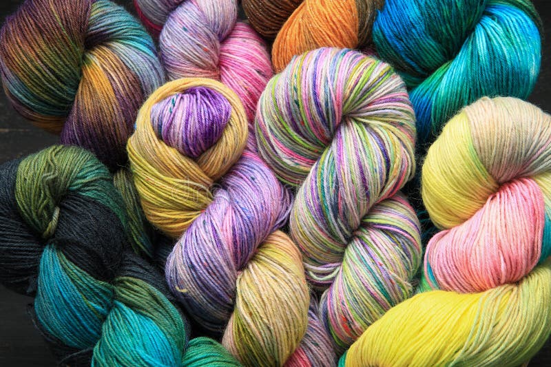 Multiple skeins of colourful handdied sock yarn, sock wool, with extreme vibrant colours for knitting socks and other craft projects as a hobby.