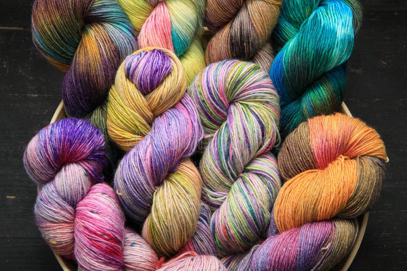 Multiple skeins of colourful handdyed sock yarn, sock wool, with extreme vibrant colours for knitting socks and other craft projects as a hobby. Multiple skeins of colourful handdyed sock yarn, sock wool, with extreme vibrant colours for knitting socks and other craft projects as a hobby.