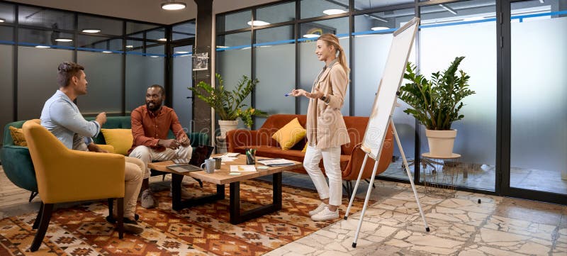 Multiracial business team having a meeting in the lounge zone in coworking office, they discussing project and sharing royalty free stock photography