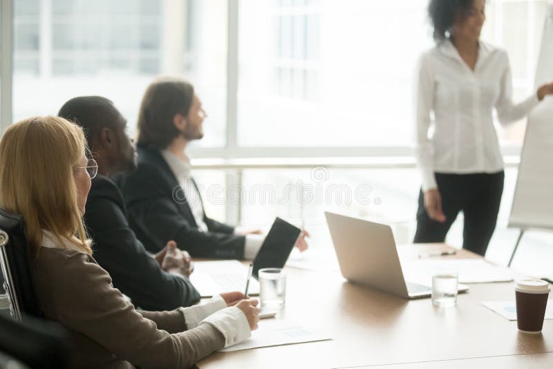 Rôznorodé podnikateľské ľudí výkonný tím počúvanie prezentácie, multiracial businesspeople sedí na konferencii stretnutie tabuľka na inštruktáž, účasť firemné skupinový tréning alebo obchodné seminár.