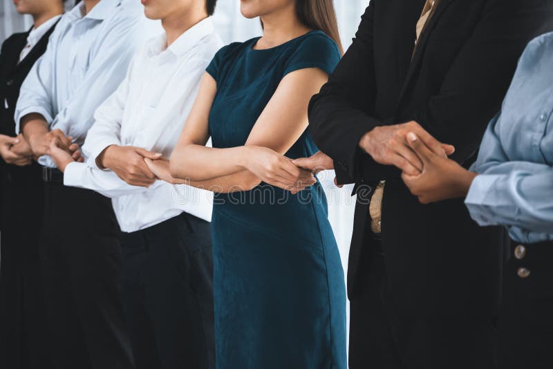 Multiracial office worker hold hand in a line promoting synergy. Concord stock photography