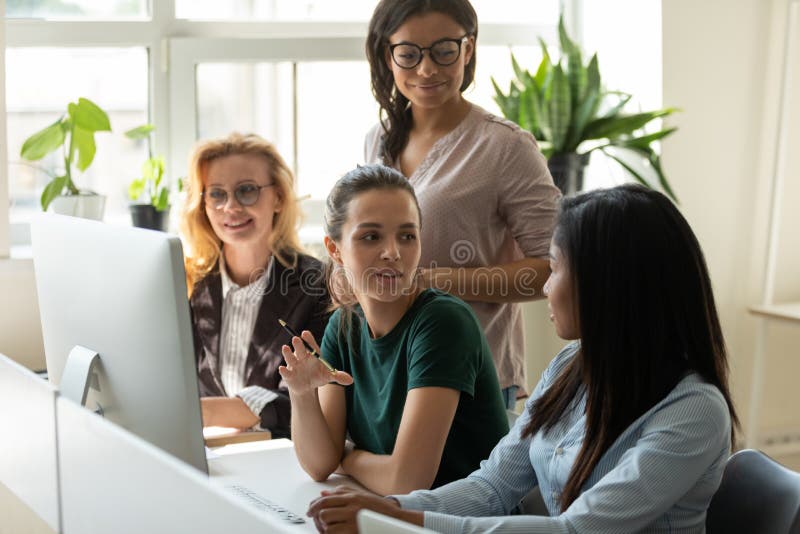 Diverse multiracial female colleagues gather at office desk collaborate discuss company financial business ideas, confident multiethnic women employees talk consider project brainstorm at meeting. Diverse multiracial female colleagues gather at office desk collaborate discuss company financial business ideas, confident multiethnic women employees talk consider project brainstorm at meeting