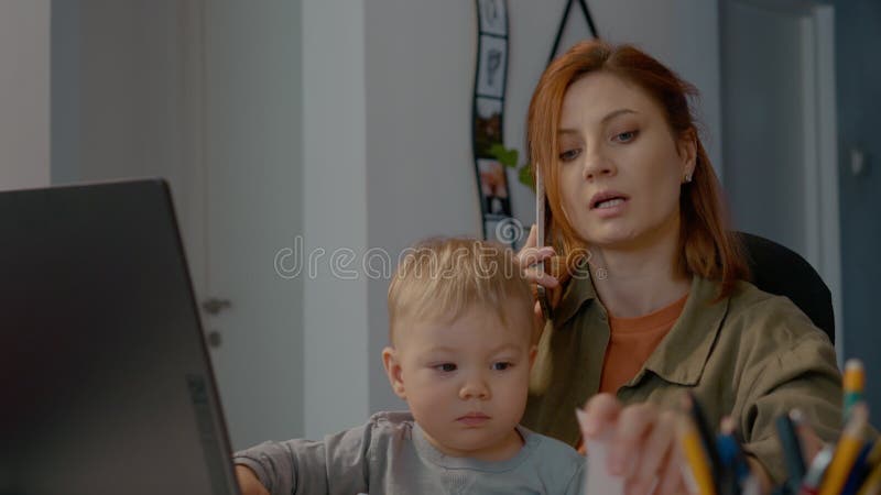 Multitasking für junge Mutter zu Hause bei der Betreuung von Kindern stock video