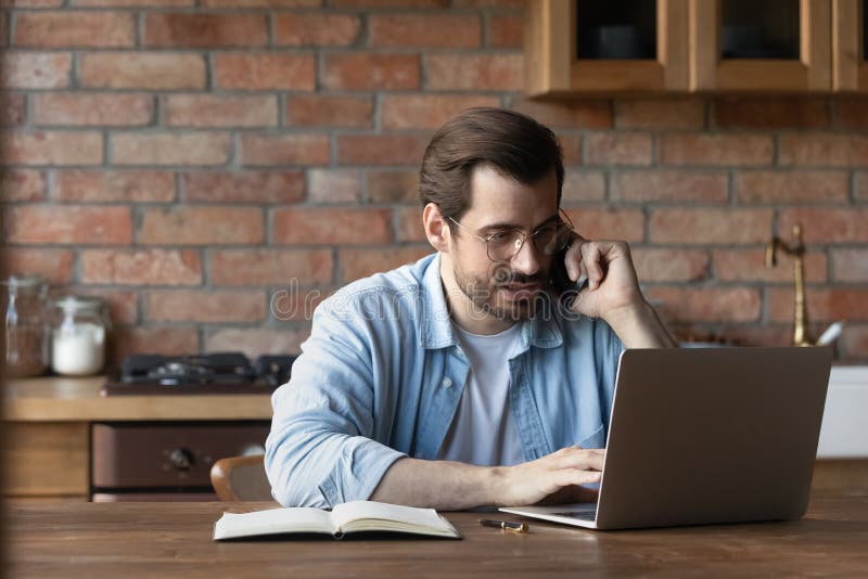 Focused Millennial Guy Work on Laptop Engaged in Telephone Conversation Stock Photo Image of
