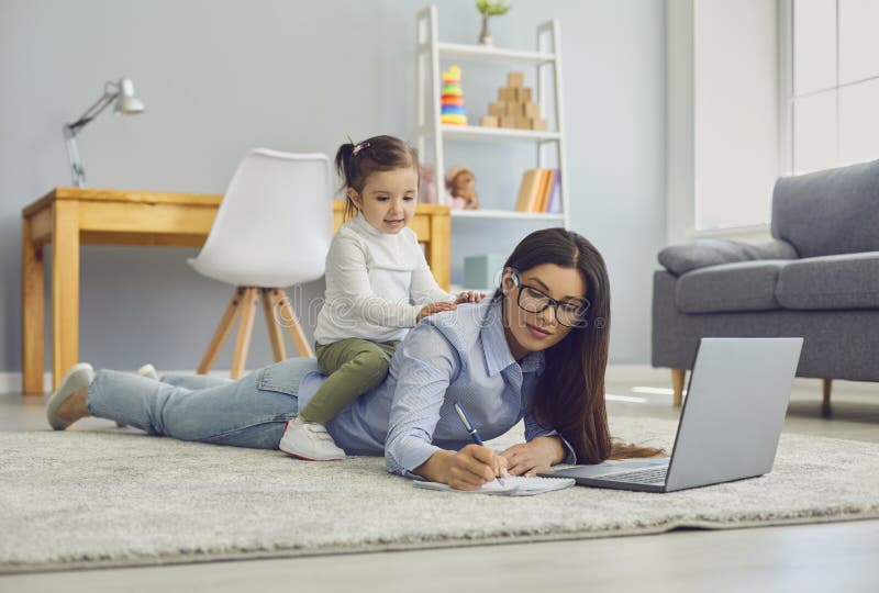 Multitasking per il lavoro nelle mamme domestiche. ragazza che lavora online sul computer portatile mentre sua figlia siede sulla