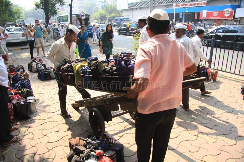 Mumbai/India - 24/11/14 - Dabbawala delivery at Churchgate Railway Station in Mumbai with two dabbawala's placing the tiffin carry royalty free stock images Mumbai/India - 24/11/14 - Dabbawala delivery at Churchgate Railway Station in Mumbai with two dabbawala's placing the tiffin carry royalty free stock images