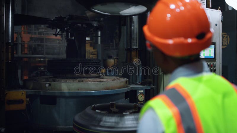Muncitor care analizează lucrările de construcție a metalelor în uzina industrială de producere a pneurilor. royalty free stock image