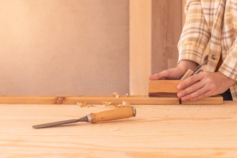 Muncitor care utilizează un plan jack pe o placă din lemn. tâmplar masculin cu fațete din lemn, cu plan înclinat royalty free stock image