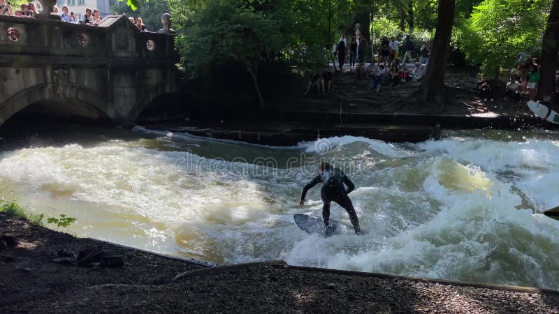 Munich allemagne 8 juillet 2024 : surfeurs surfent sur les vagues au bord sud du jardin anglais banque de vidéos